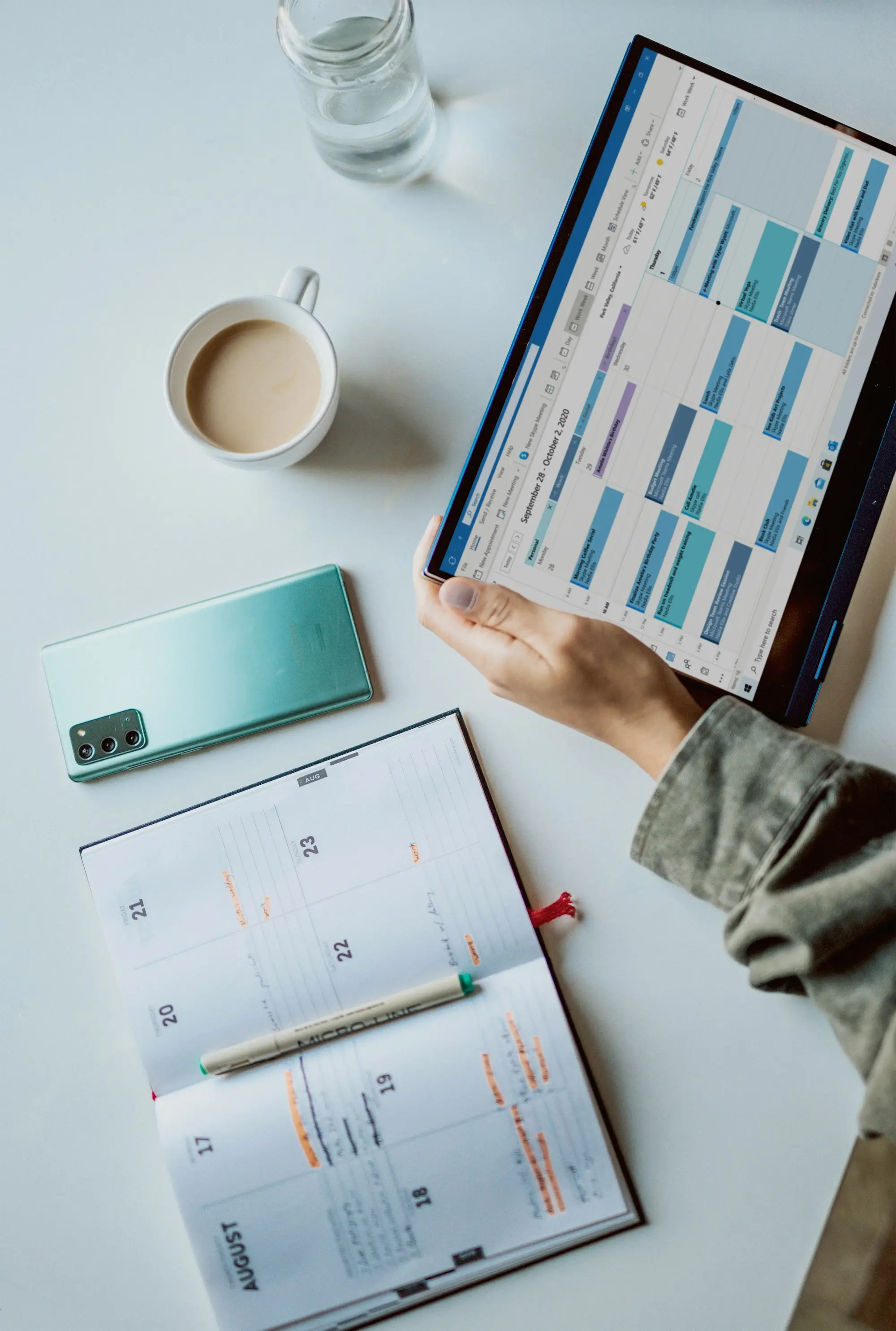 Business owner mapping repayment dates on a tablet calendar beside a laptop and coffee