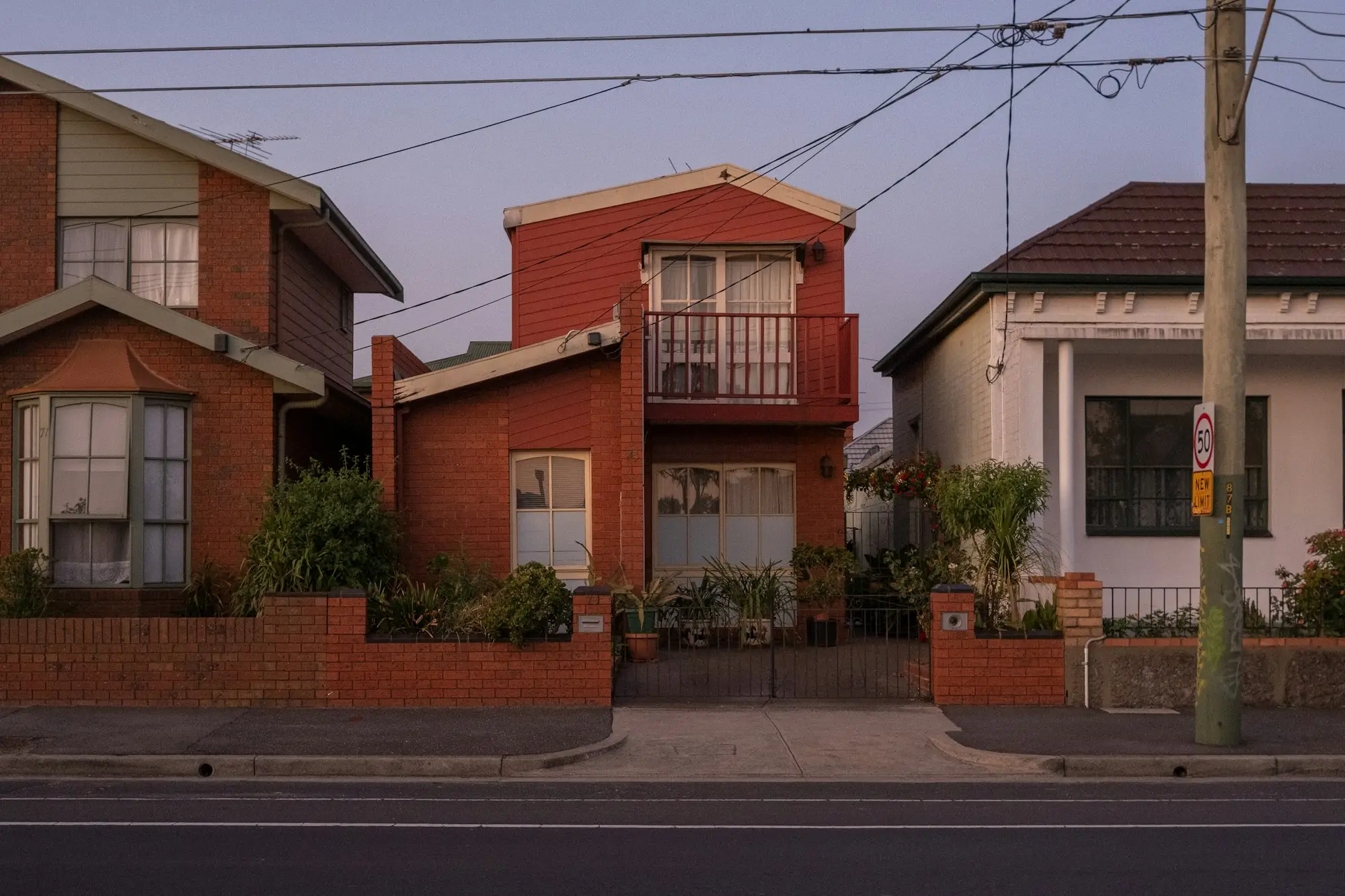 Red-brick townhouses and units side by side on an Australian suburban street