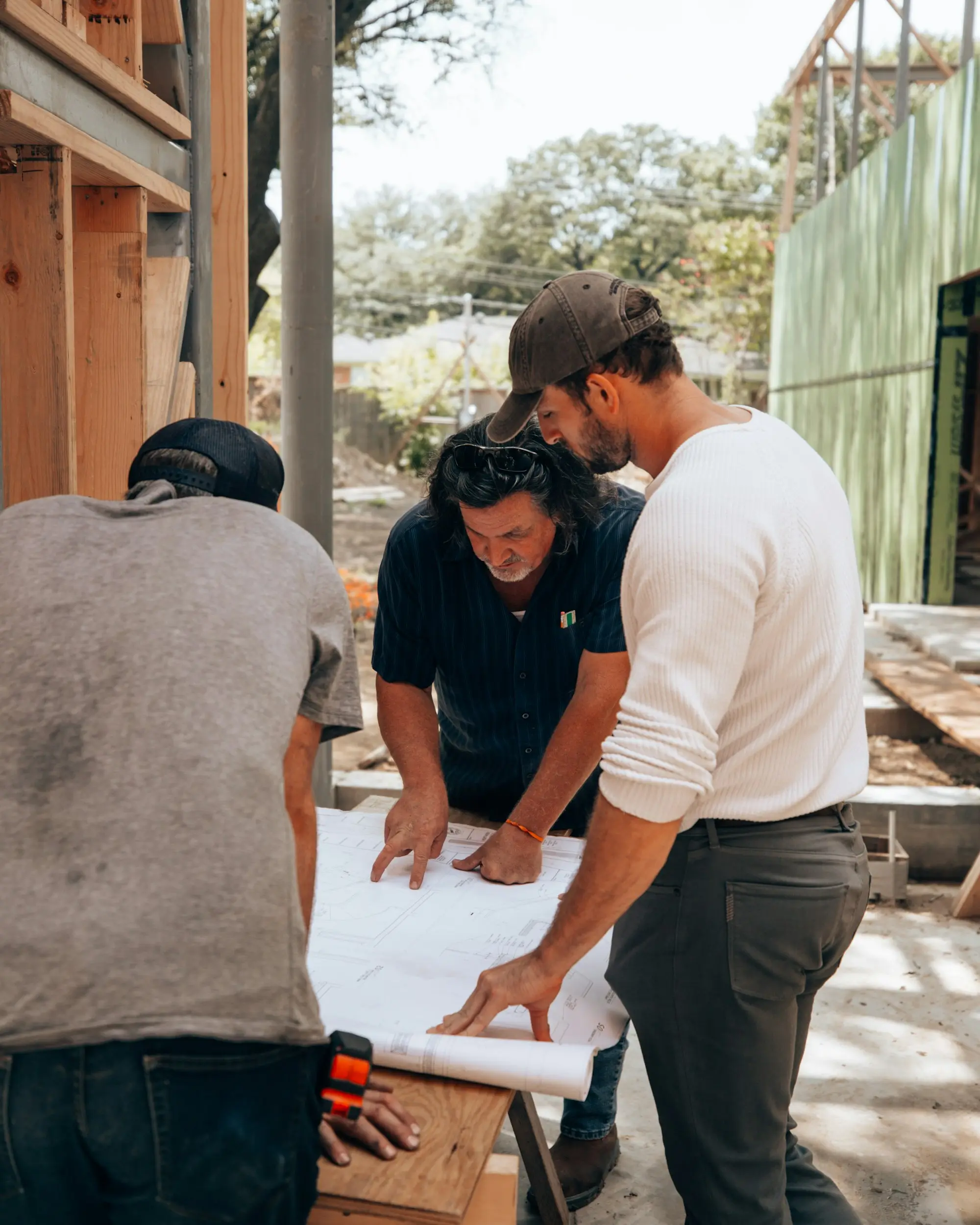 Builders reviewing project plans on site after winning a tender